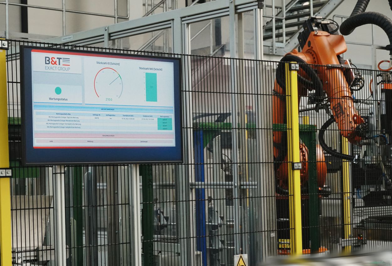 Shopfloor-Dashboard der B&T Exact GmbH: Echtzeit-Monitor mit OEE-Kennzahlen und Industrieroboter in der Fertigung